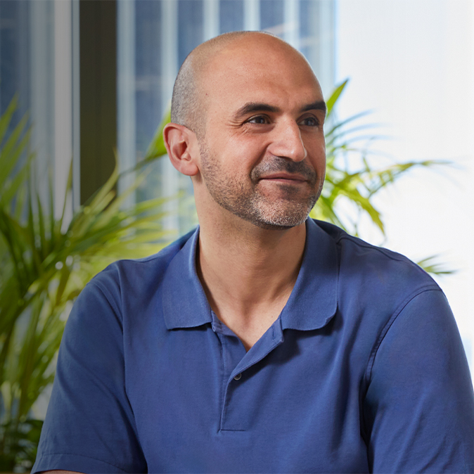 Ahmed가 실내에 앉아 자신의 왼쪽을 바라보고 있음.