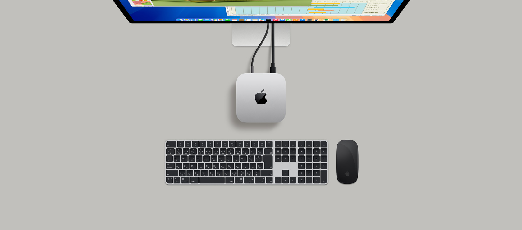 ディスプレイにつながれたシルバーのMac miniを上から見た図。ディスプレイにはKeynoteとMicrosoft Excelのウインドウが表示されている
