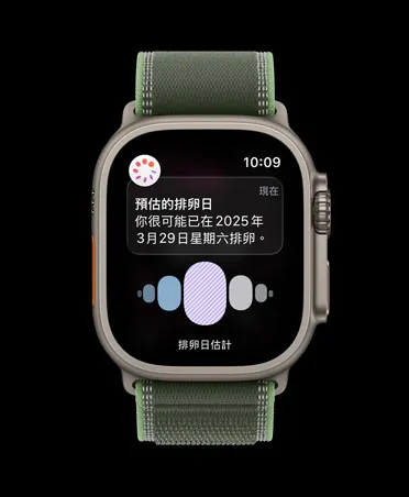 原色鈦金屬錶殼搭配綠色配霓虹綠色越野錶環的 Apple Watch Ultra 3，展示健康 app 裡經期追蹤功能的排卵日預測通知