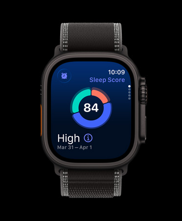 Apple Watch Ultra 3 med urkasse av svart titan og Trail Loop i svart/koksgrå viser et sirkeldiagram med søvnscore på skjermen.