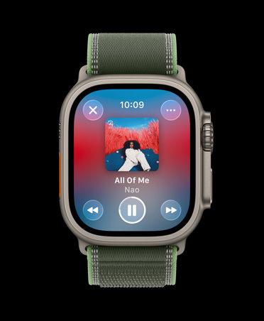 Apple Watch Ultra 3 med urkasse av naturlig titan og Trail Loop i grønn/neon viser en treningsspilleliste i Apple Music med kontroller for forrige sang, neste sang og pause.