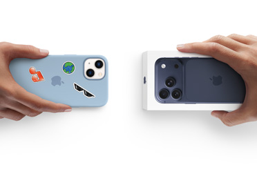 Händer som byter in en iPhone 13 i silikonskal med klistermärken på baksidan mot en ny iPhone 17 Pro som ligger i sin förpackning.